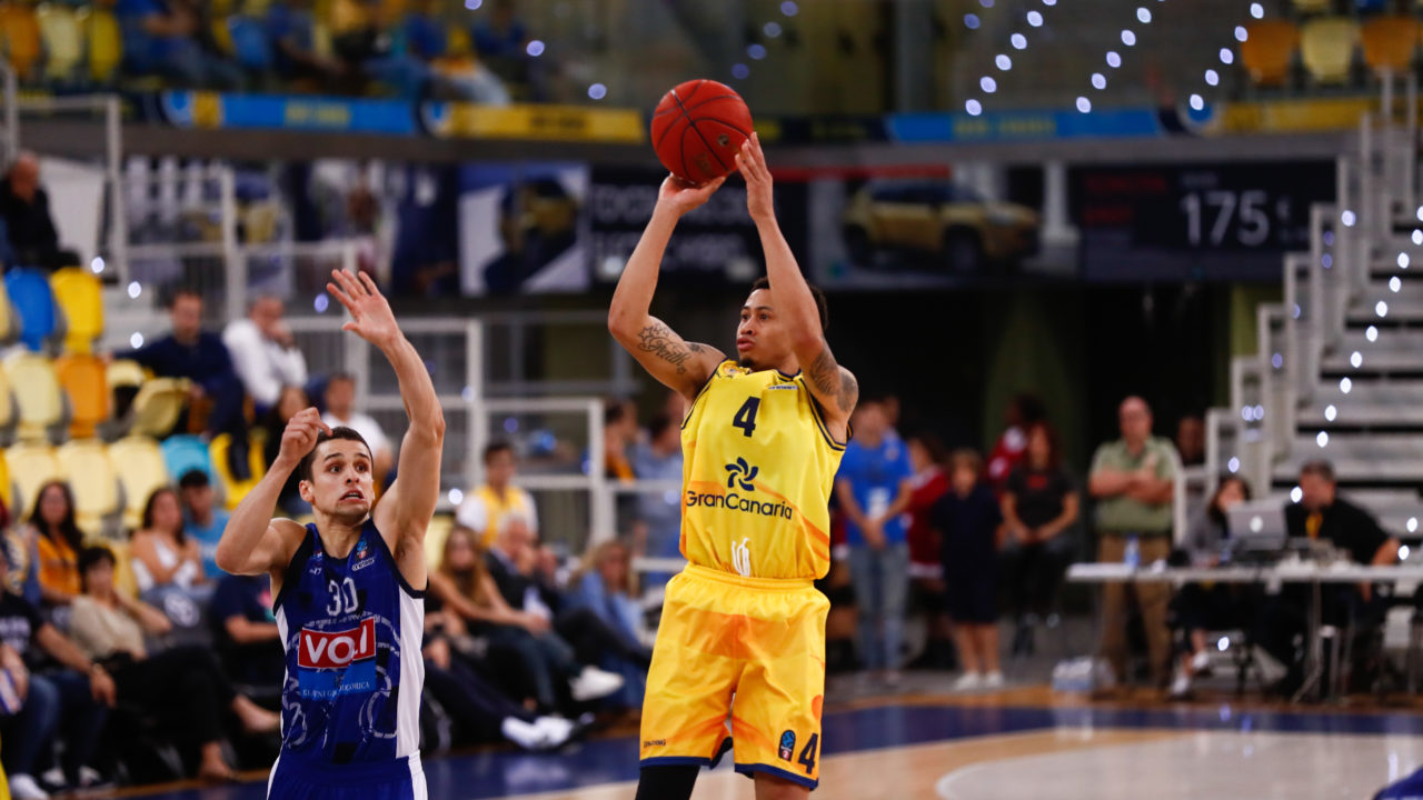 Jugador del Gran Canaria en acción lanzando a canasta durante un partido en Polonia.