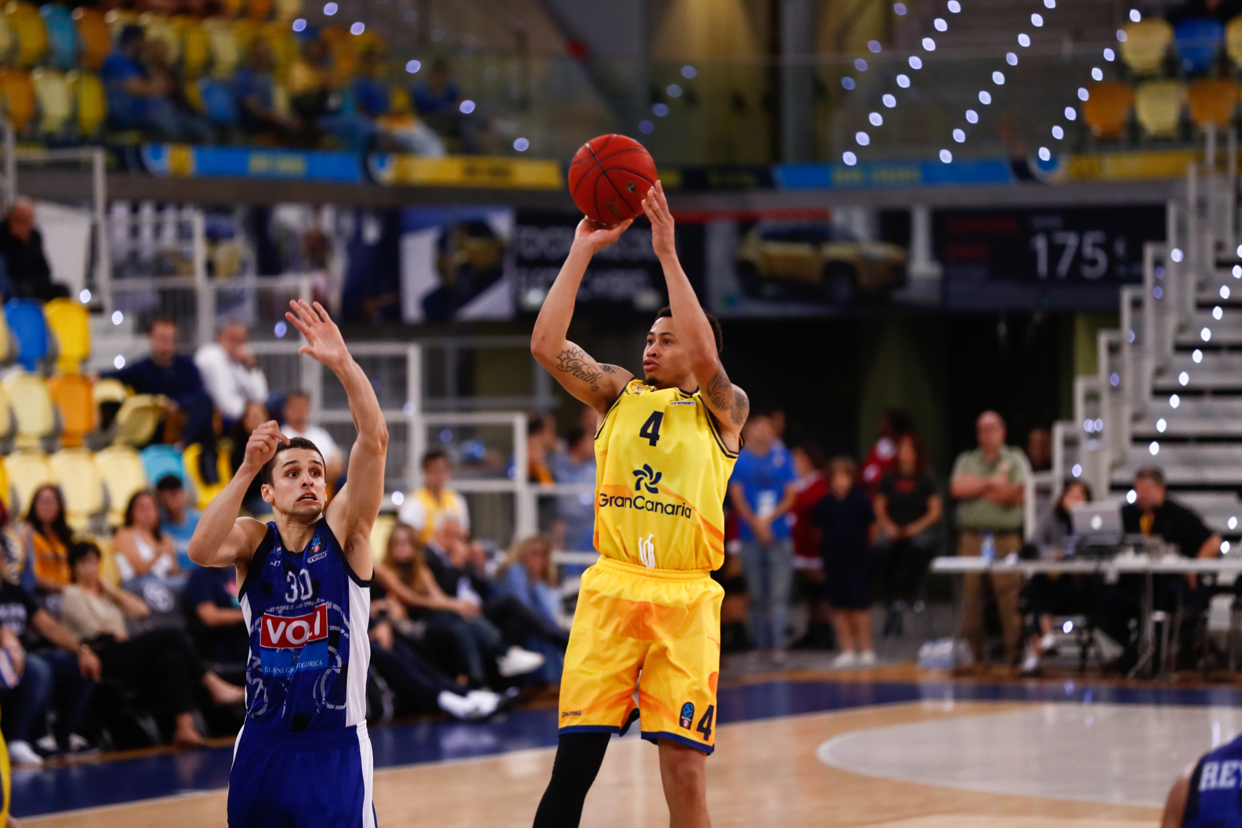 Jugador del Gran Canaria en acción lanzando a canasta durante un partido en Polonia.