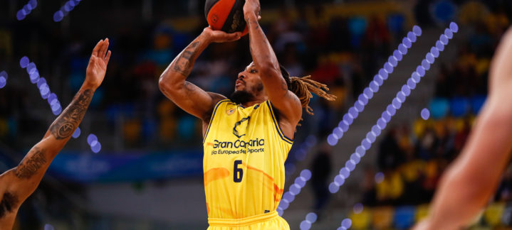 Jugador del Gran Canaria lanzando el balón a canasta durante un partido en casa.