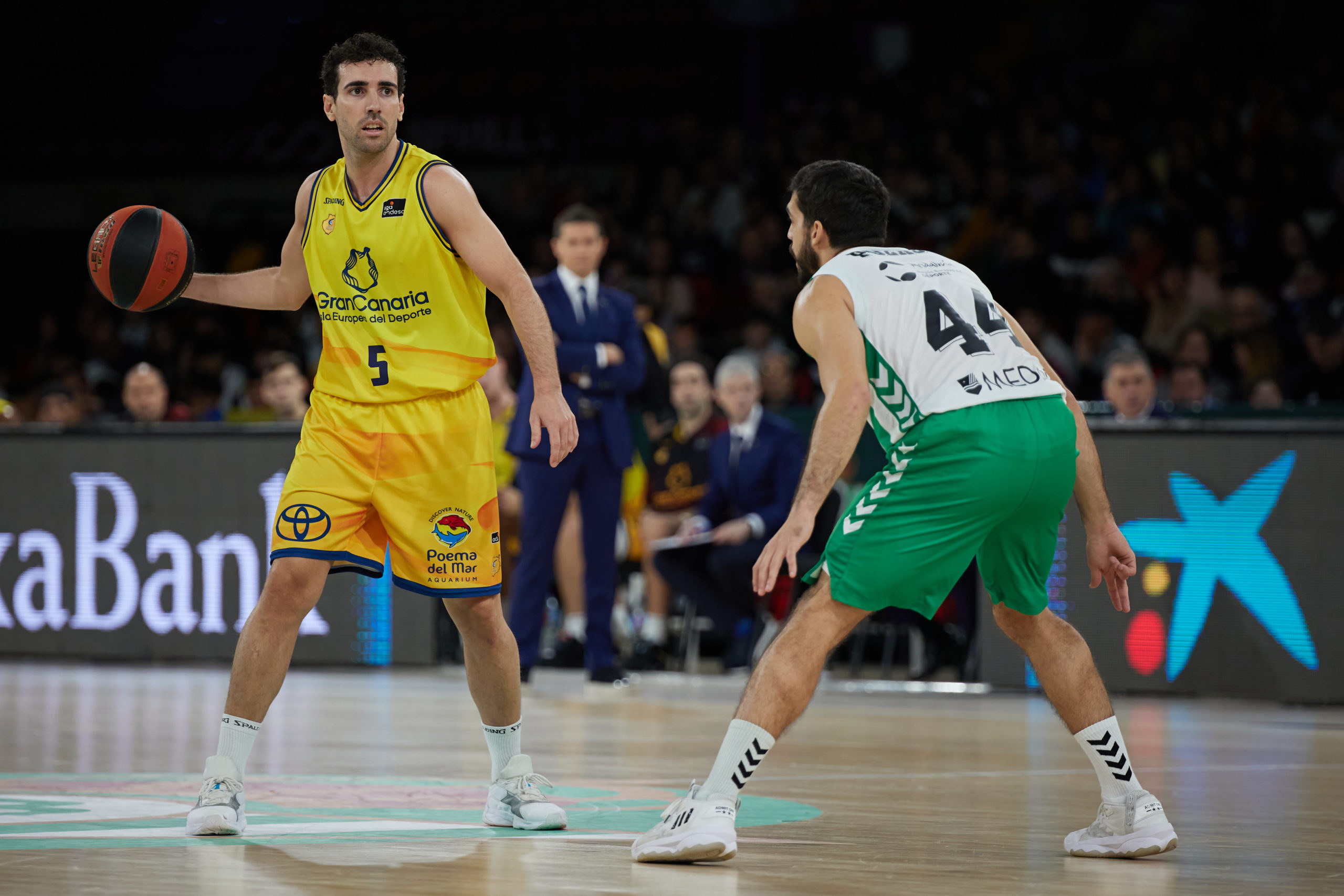 Jugadores de baloncesto en acción durante un partido entre Gran Canaria y Real Betis.