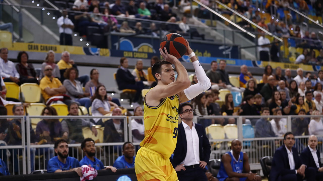 Jugador del Club Baloncesto Gran Canaria se prepara para lanzar el balón en el arena.