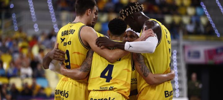 Jugadores del Club Baloncesto Gran Canaria se abrazan en un momento de unidad y motivación.