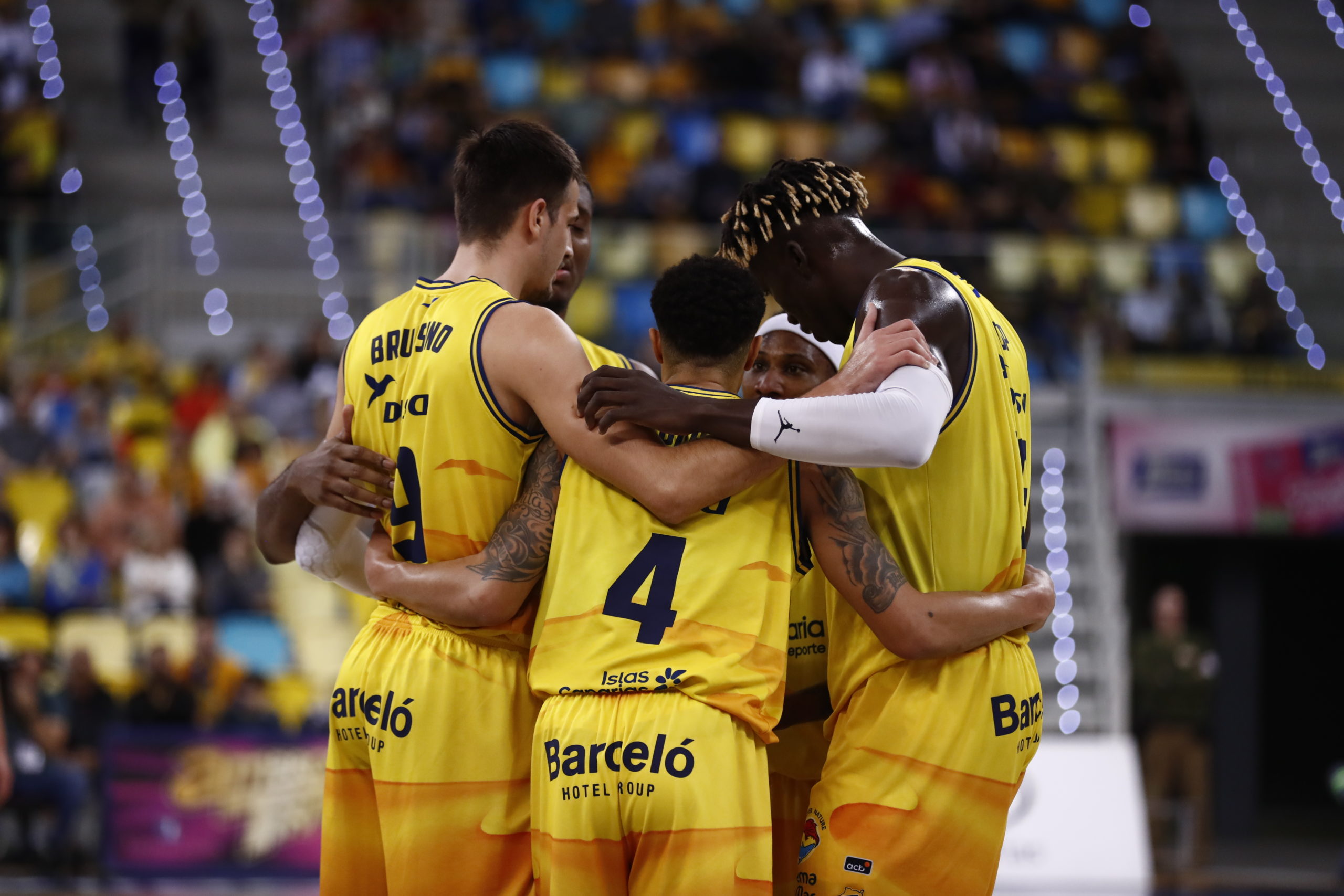 Jugadores del Club Baloncesto Gran Canaria se abrazan en un momento de unidad y motivación.