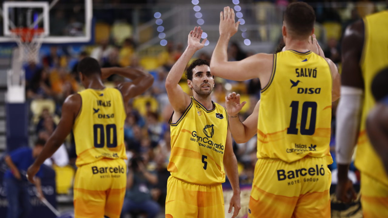 Jugadores del Gran Canaria celebran una jugada en un partido de baloncesto.