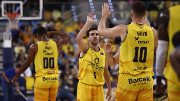 Jugadores del Gran Canaria celebran una jugada en un partido de baloncesto.