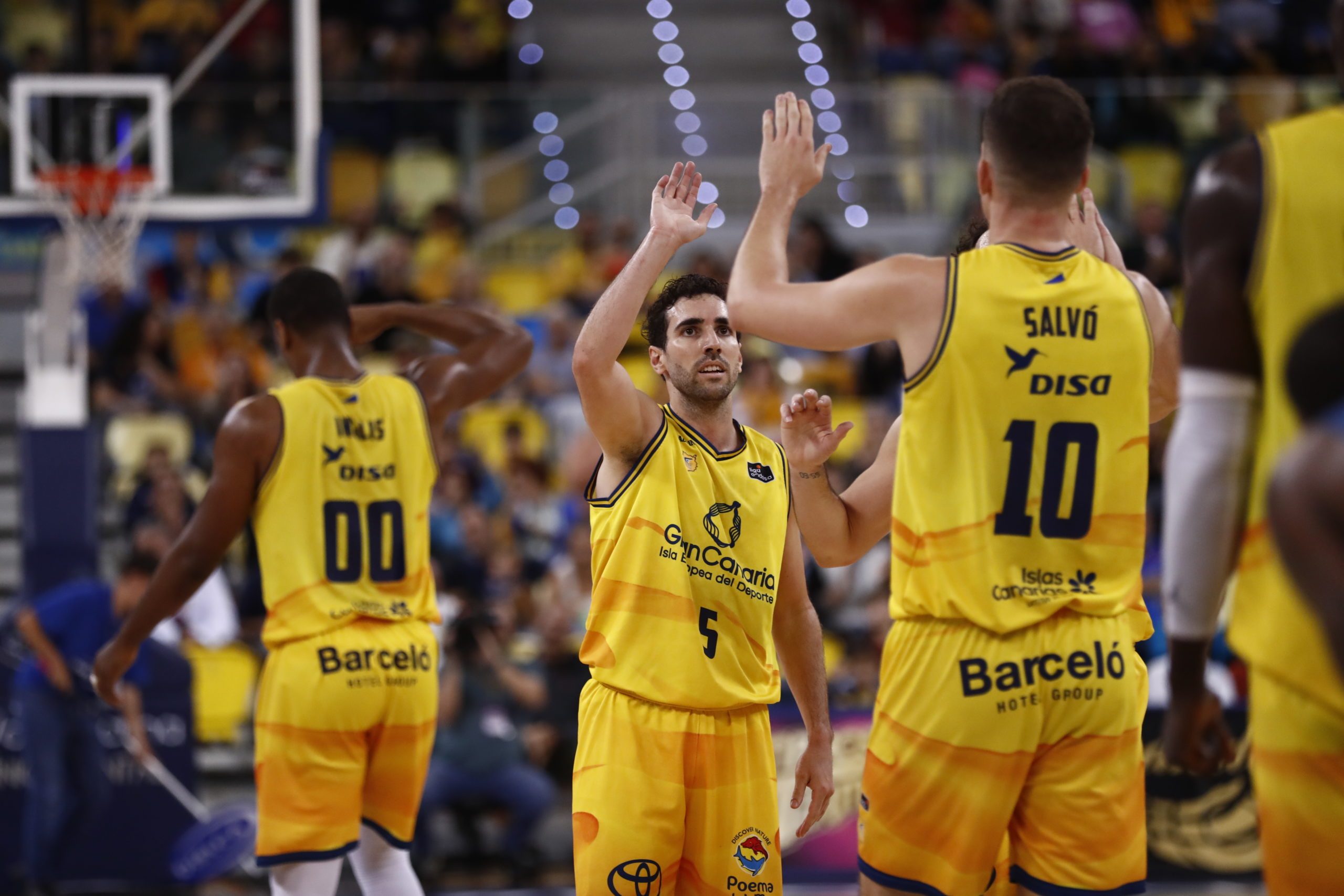 Jugadores del Gran Canaria celebran una jugada en un partido de baloncesto.