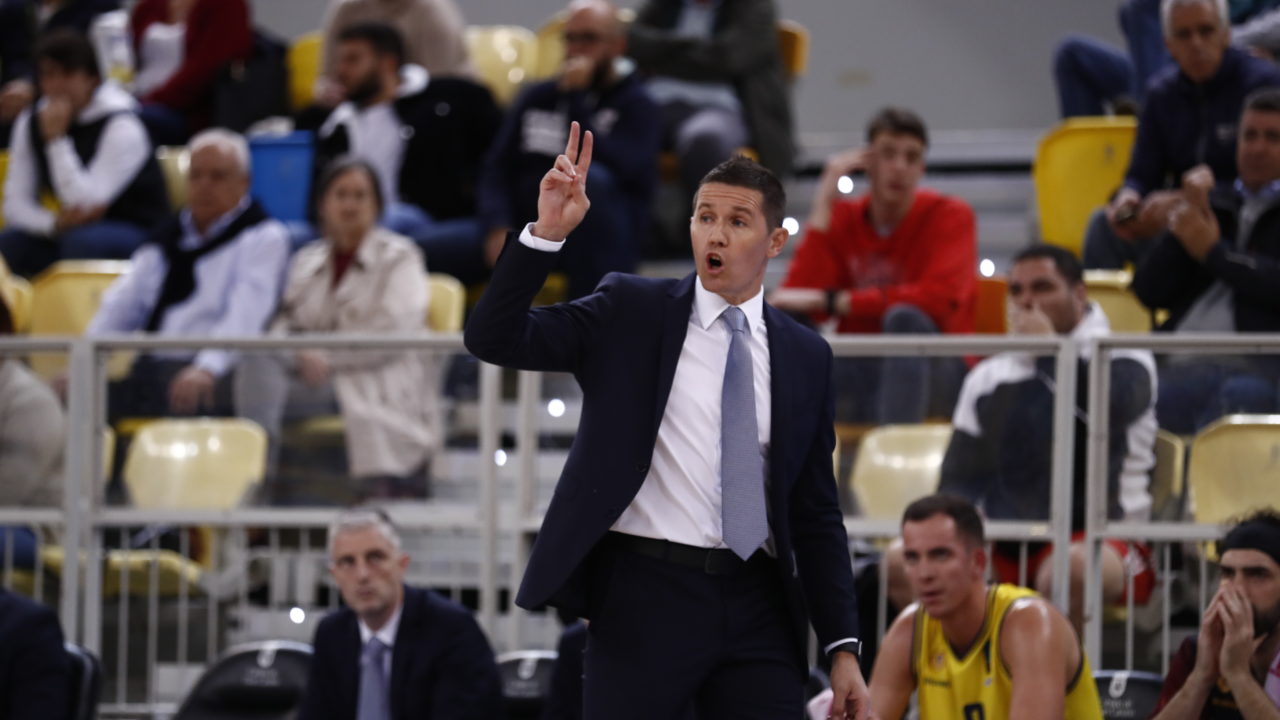 Entrenador Jaka Lakovic dirigiendo al equipo durante un partido, con público de fondo.