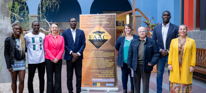 Grupo de personas posando junto a un cartel sobre la colaboración entre Canarias y África.