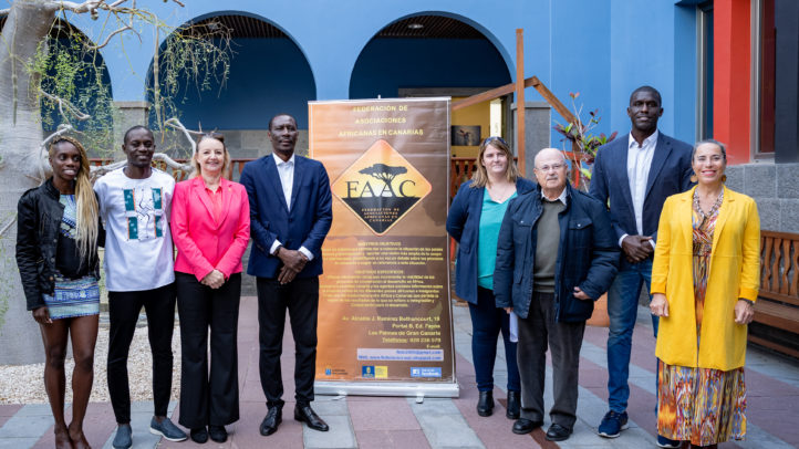 Grupo de personas posando junto a un cartel sobre la colaboración entre Canarias y África.