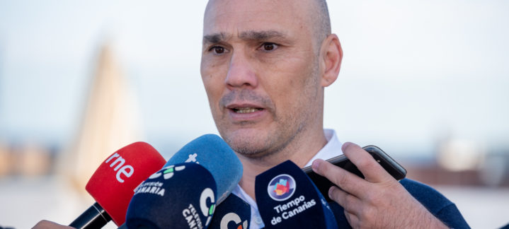 Entrenador del CB Gran Canaria habla a la prensa rodeado de micrófonos.
