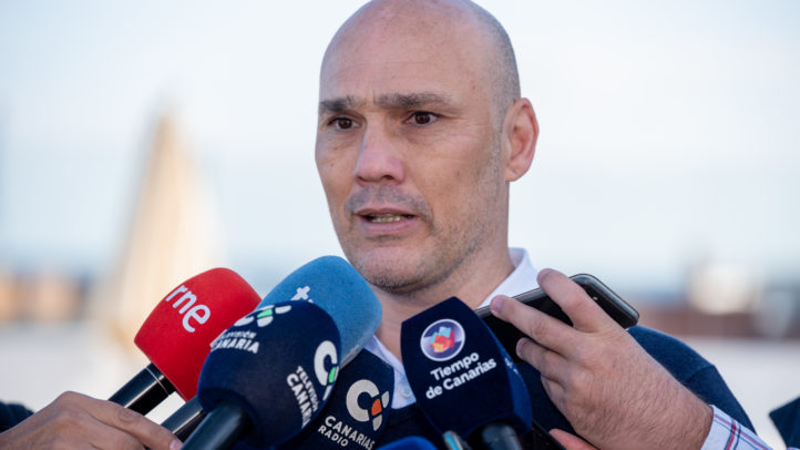 Entrenador del CB Gran Canaria habla a la prensa rodeado de micrófonos.