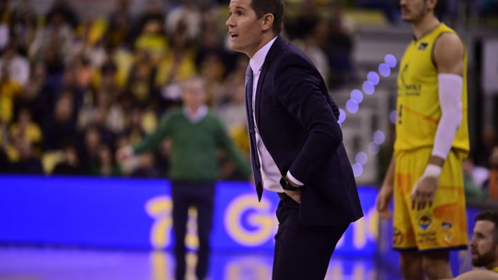 Entrenador Jaka Lakovic dirigiendo al equipo durante un partido, con jugadores de fondo.