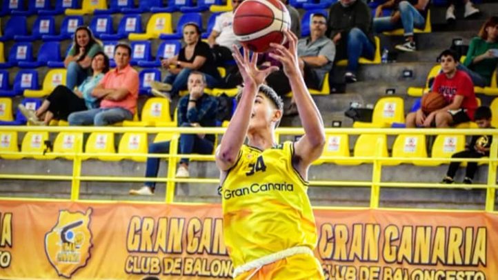 Jugador de baloncesto en acción, lanzando una pelota en un partido del Club Gran Canaria.