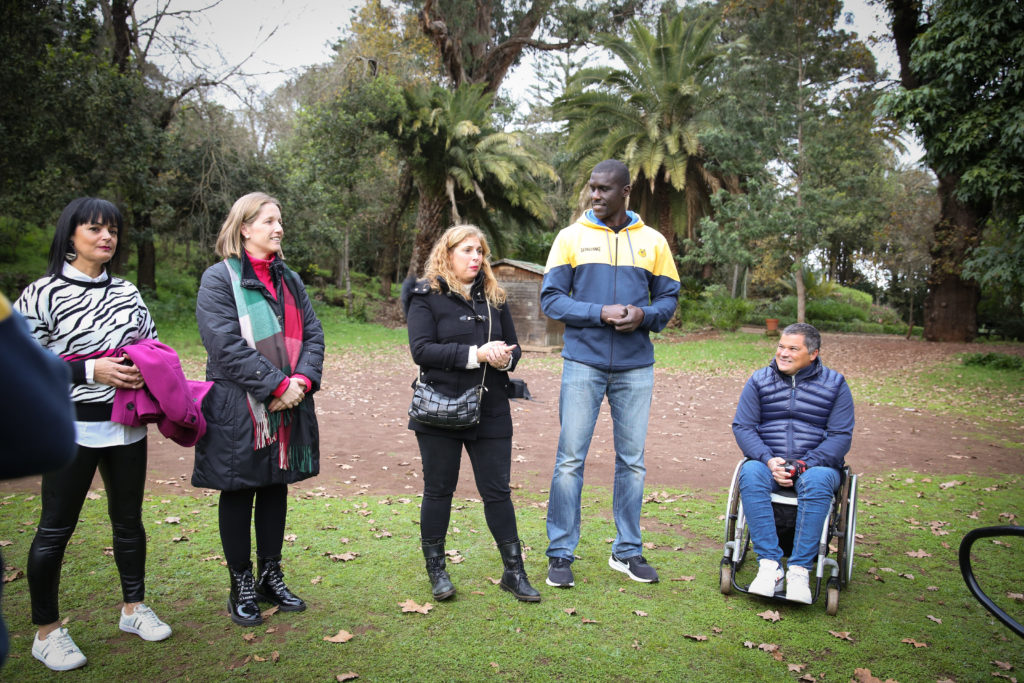 Grupo de personas en un parque durante una sesión de senderismo inclusivo.