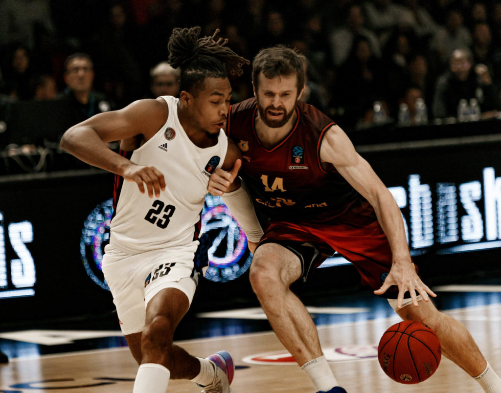 Jugadores compiten por el balón en un partido de baloncesto emocionante.