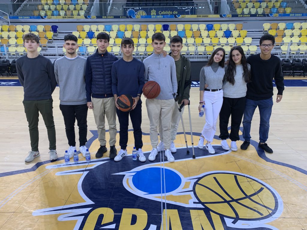 Grupo de jóvenes en la cancha del CB Gran Canaria, participación en actividad educativa.