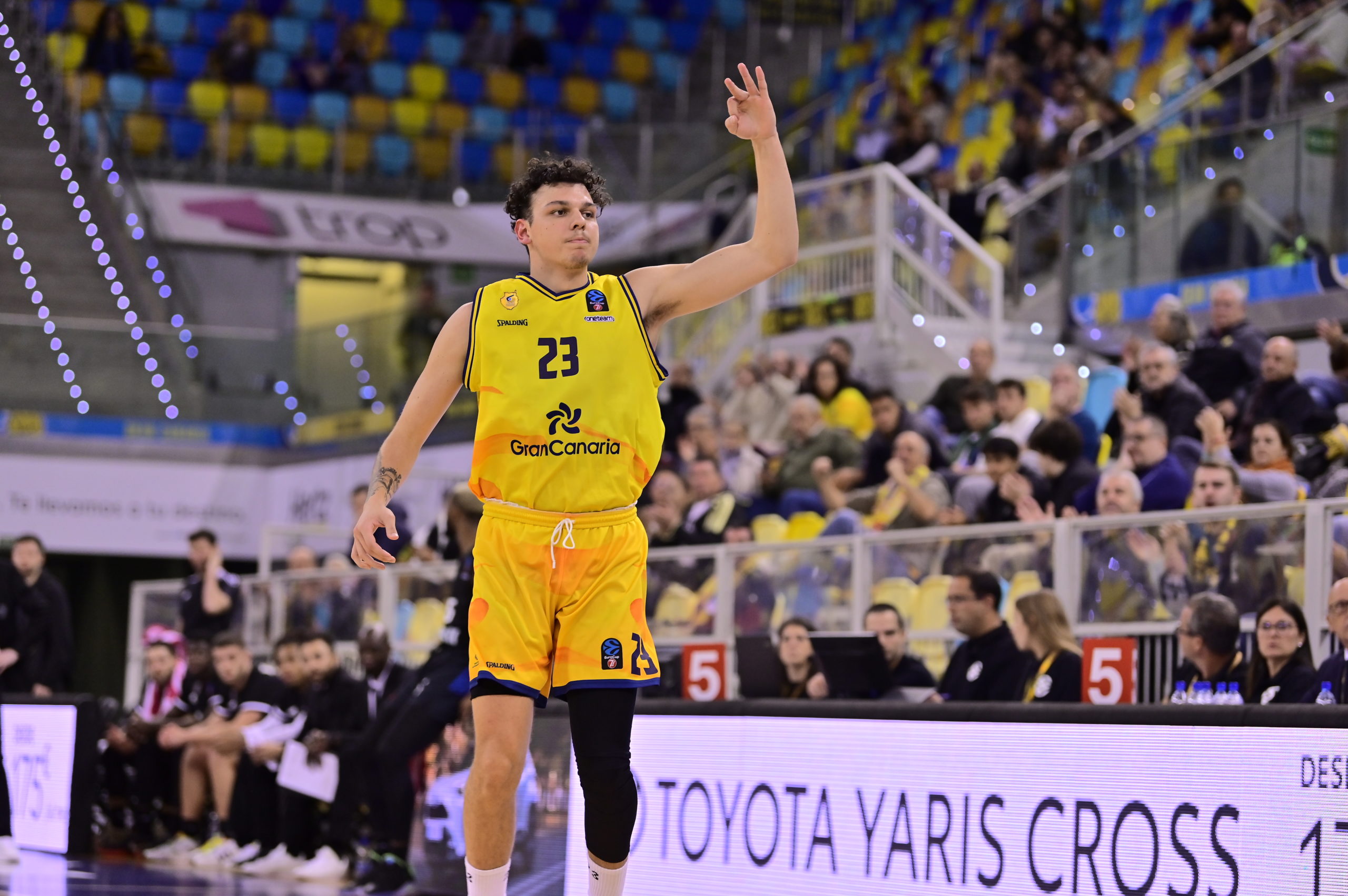 Jugador del Gran Canaria celebra un punto durante el partido, vestido con uniforme amarillo.
