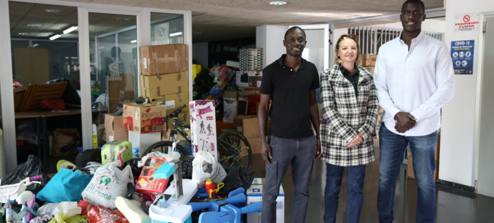 Tres personas posan junto a donaciones para la campaña solidaria Senegal y Gambia.