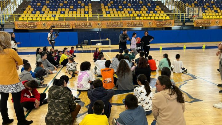 Actividad grupal en el campo de baloncesto con niños y entrenadores.