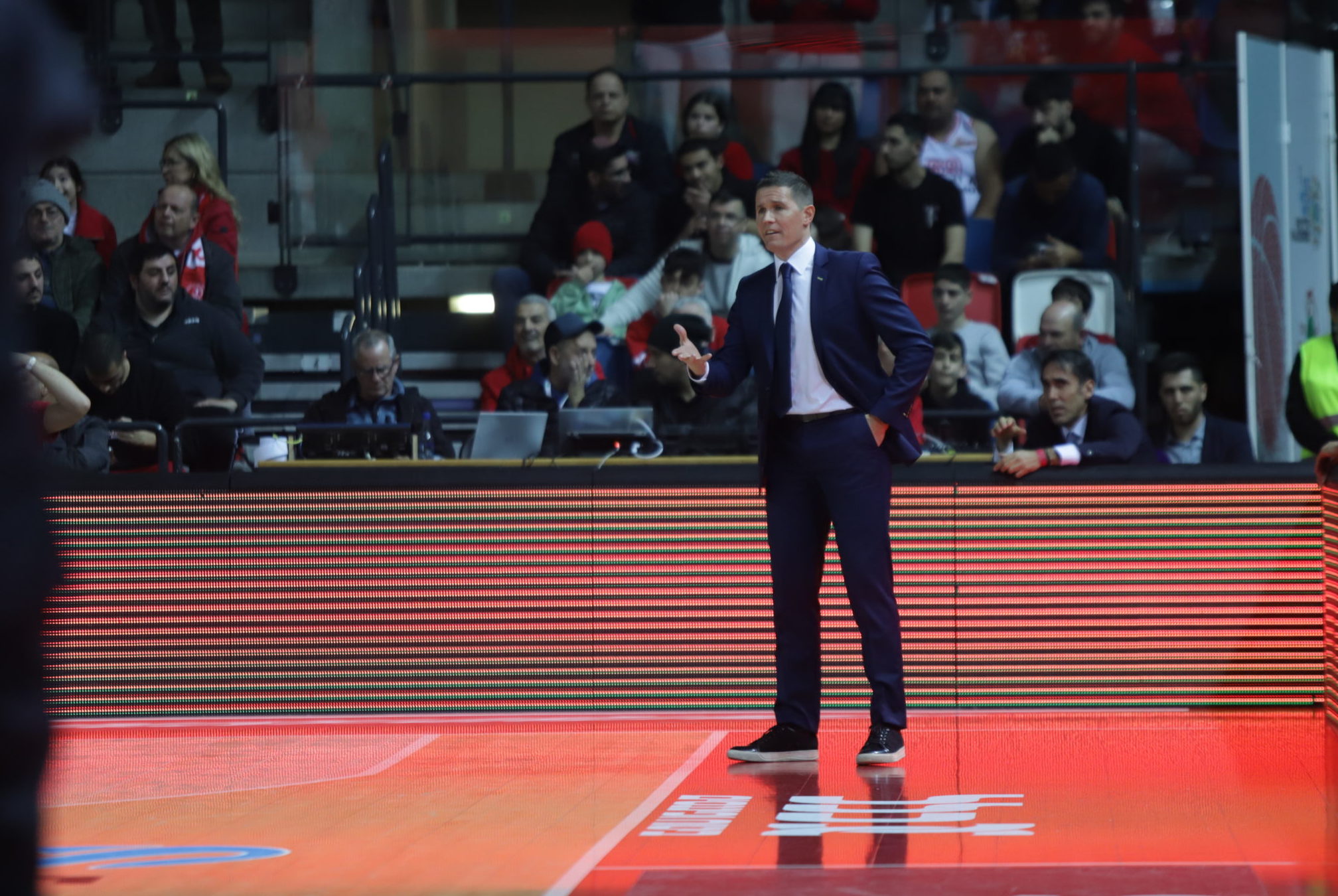 Entrenador Jaka Lakovic dirigiendo al equipo durante un partido con público presente.