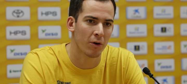 Jugadora del CB Gran Canaria en una rueda de prensa con fondo amarillo y patrocinadores.