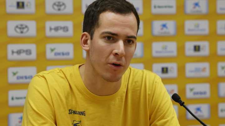 Jugadora del CB Gran Canaria en una rueda de prensa con fondo amarillo y patrocinadores.