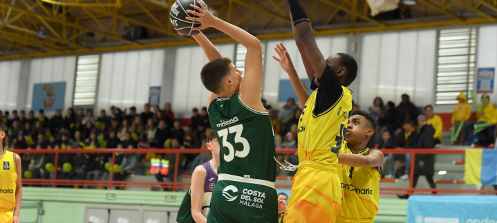 Jugador en acción lanzando el balón a canasta durante un partido de baloncesto.