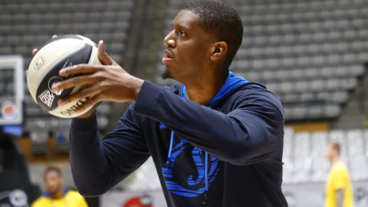 Jugador practicando tiros con un balón de baloncesto en un entrenamiento.