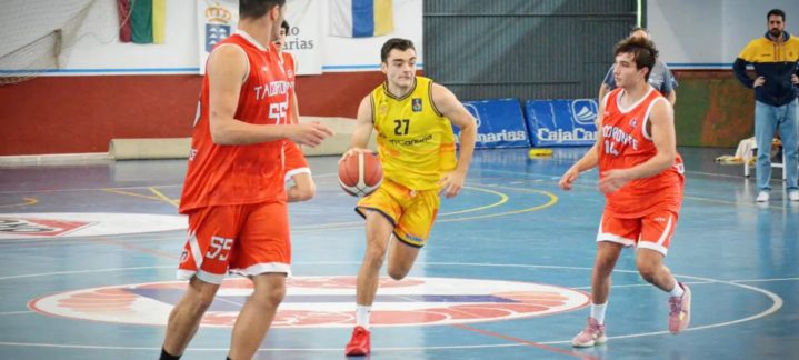 Jugadores de baloncesto compiten en una cancha, con uno en amarillo y dos en rojo.