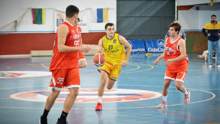 Jugadores de baloncesto compiten en una cancha, con uno en amarillo y dos en rojo.