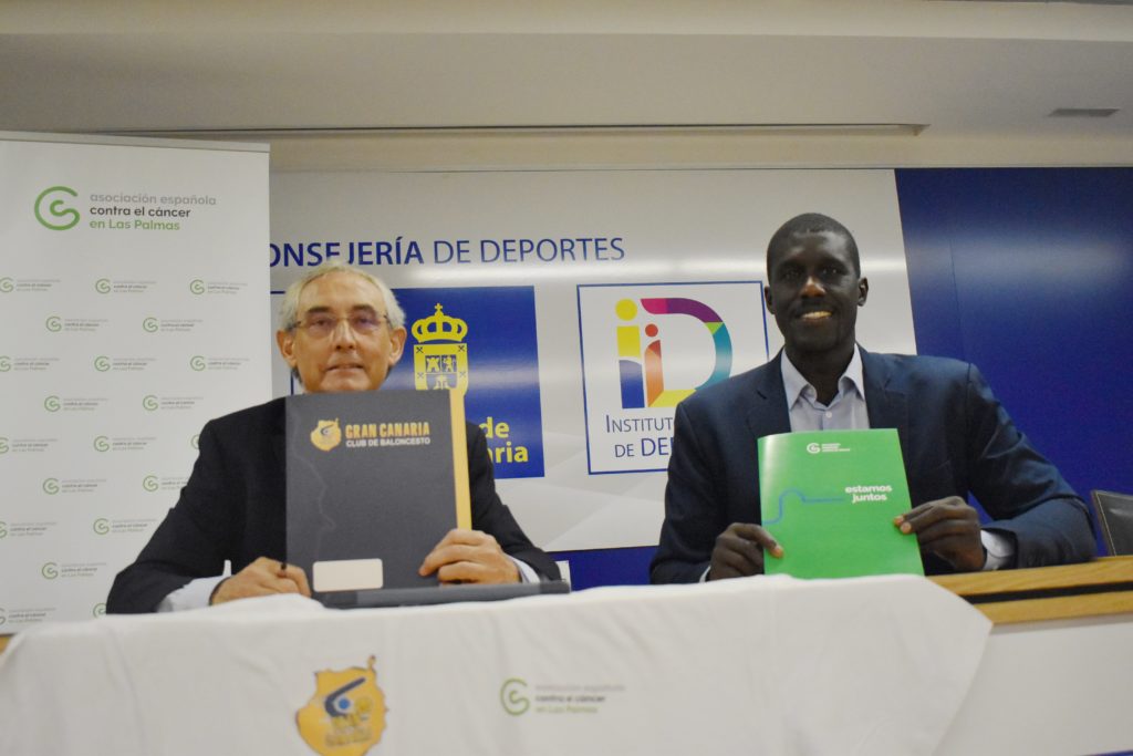 Dos representantes sostienen documentos sobre el Proyecto Carmen en una rueda de prensa.