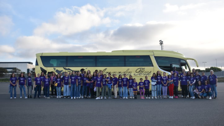 presente en la manifestación del 8M",Grupo de personas con camisetas moradas frente a un autobús amarillo.