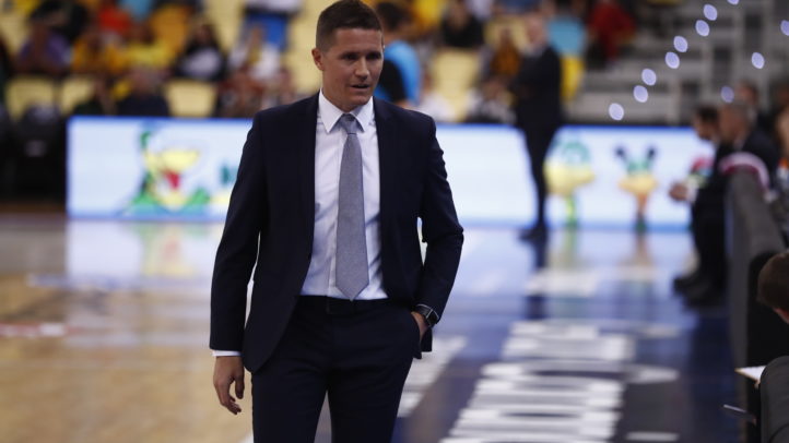 Entrenador del Club Baloncesto Gran Canaria durante un partido, con actitud reflexiva.