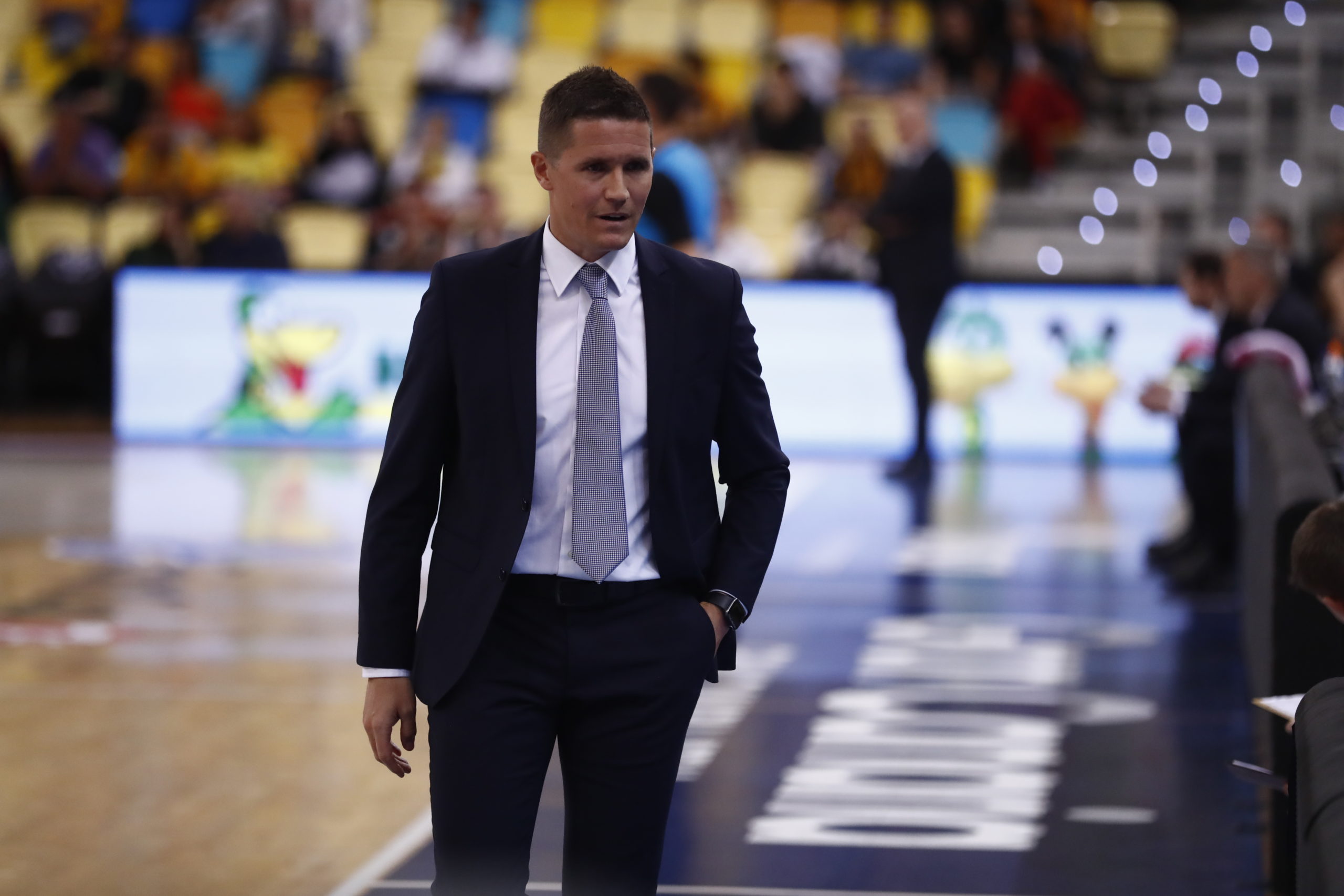Entrenador del Club Baloncesto Gran Canaria durante un partido, con actitud reflexiva.