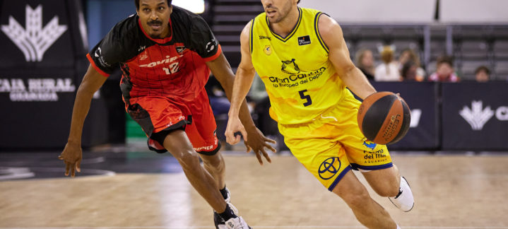Jugador del Gran Canaria avanza con el balón, perseguido por un rival del Covirán Granada.