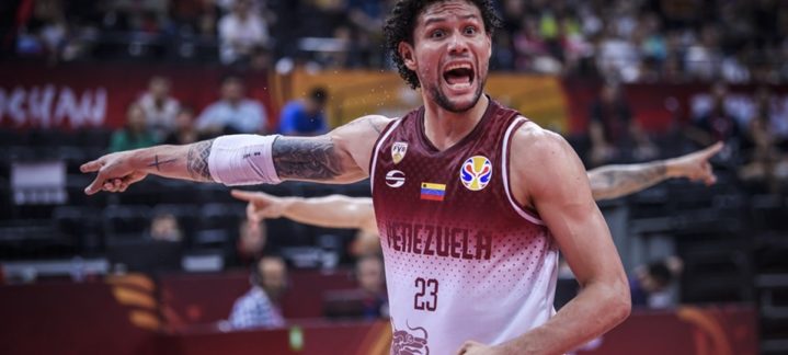 Michael Carrera gesticula intensamente durante un partido de baloncesto.