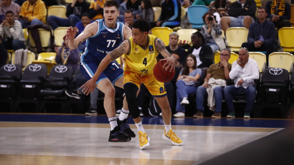 Jugador del Gran Canaria driblando el balón, mientras es defendido por un rival del Turk Telekom.