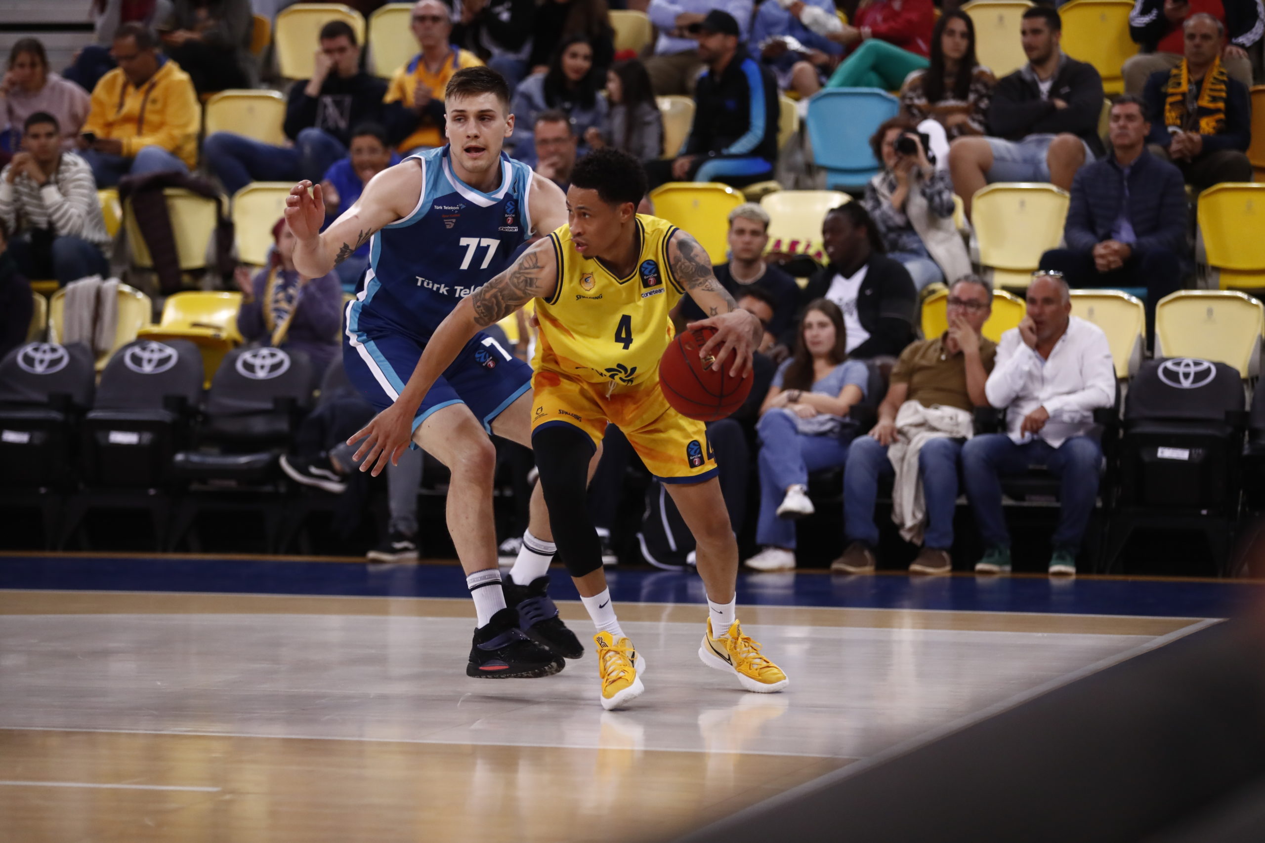Jugador del Gran Canaria driblando el balón, mientras es defendido por un rival del Turk Telekom.