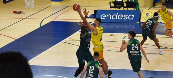 Jugadores de baloncesto en acción, uno lanzando a canasta y otros en defensa.