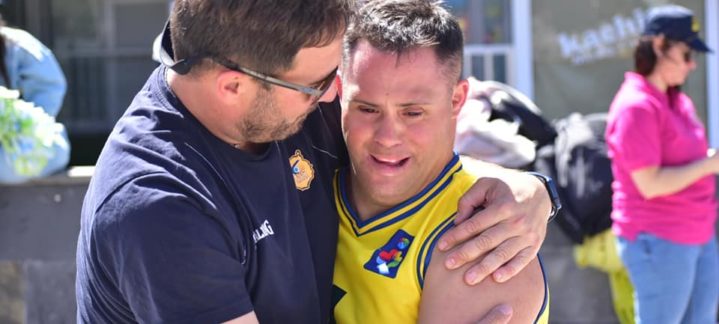 Dos personas se abrazan con alegría en un evento de baloncesto inclusivo.