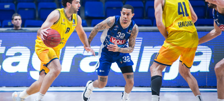 Jugadores en acción durante un partido de baloncesto, con un jugador driblando.