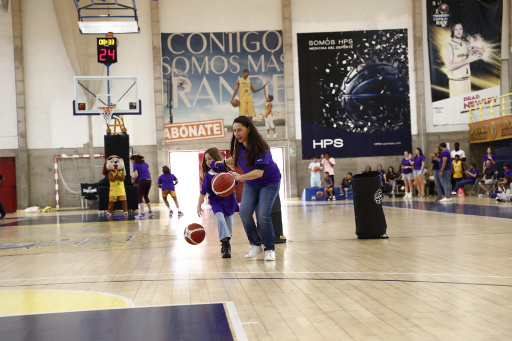 Jóvenes y adultos participan en actividades de baloncesto en un evento familiar.