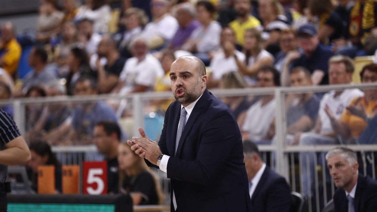 Entrenador Victor García dirigiendo a su equipo ante un público animado.