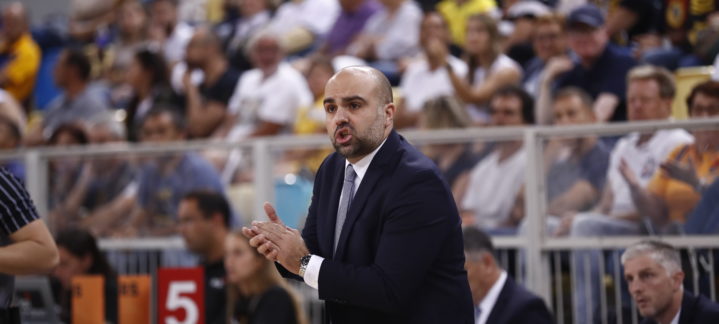 Entrenador Victor García dirigiendo a su equipo ante un público animado.