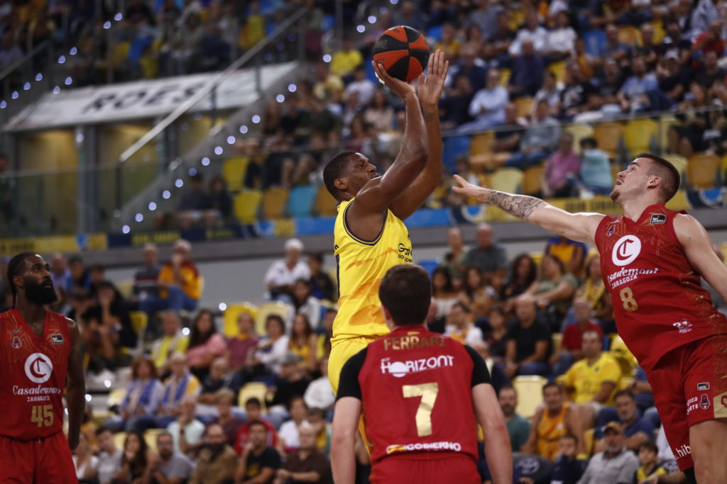 Jugador del Gran Canaria intenta encestar mientras es defendido por un rival del Zaragoza.