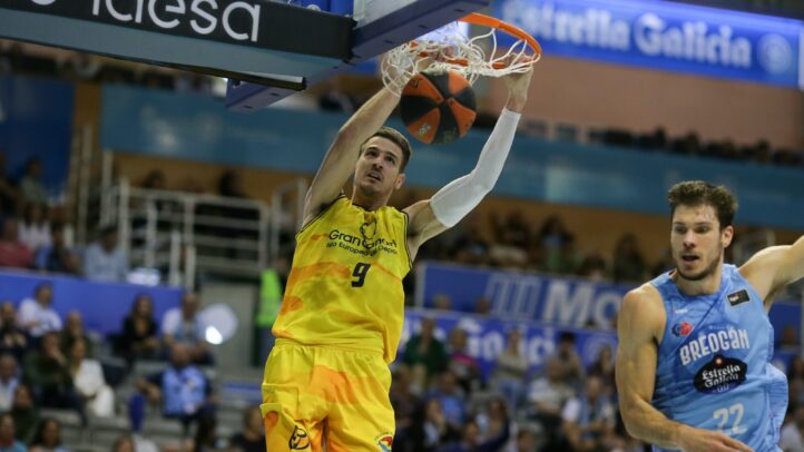 Jugador del Gran Canaria realiza un mate mientras un rival observa durante el partido.