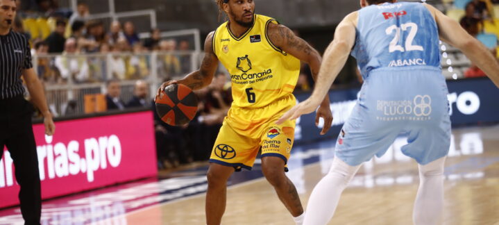 Jugadores del Gran Canaria en acción durante un partido de la ACB, con ataque y defensa.