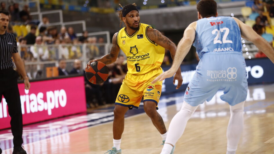 Jugadores del Gran Canaria en acción durante un partido de la ACB, con ataque y defensa.