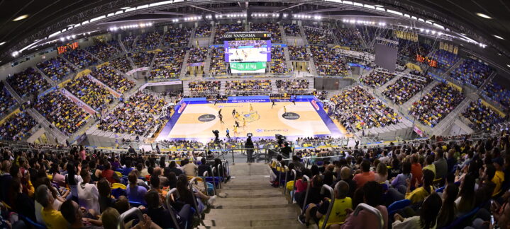 Aficionados disfrutan de un partido de baloncesto en el Gran Canaria Arena llenando las gradas.