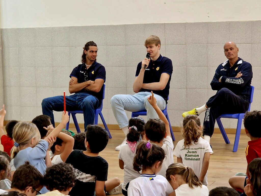 Miguel Serrano y Nazar Kulishenko conversan con niños en un aula del colegio.